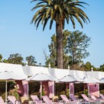The Pink Palace's iconic pink-and-white pool area is home to the French beauty and fashion brand's summer pop-up