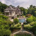 This sprawling home near the border of New York and Connecticut features a putting green, gorgeous pool and indoor basketball court