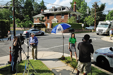 Reporters and photographers set up across the street from the Savopoulos mansion on Woodland Drive