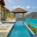 This three-bedroom Caribbean oasis boasts an infinity lap pool with striking island views