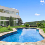 This high-tech property in Bedford, New York is a pristine retreat with a gorgeous pool, tennis courts and great views all around